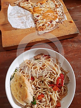 Appetizing aglio e olio pasta and cheese pizza