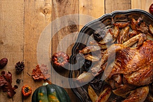 Appetizing baked turkey, potato and mushrooms on wooden background with autumn harvest. Festive dinner. Thanksgiving day concept.