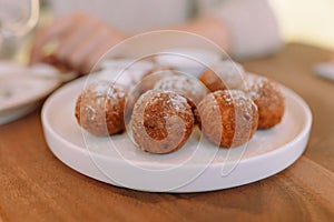 Appetizing and beautiful round fried donuts on a white plate