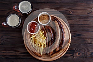 Appetizing beer snacks plate. Grilled sausages and french fries