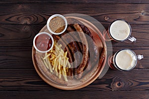 Appetizing beer snacks plate. Top view on table with grilled sau