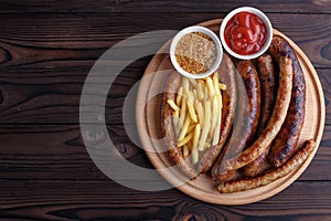 Appetizing beer snacks set. Grilled sausages and french fries se