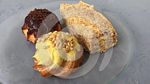 Appetizing cakes on a transparent plate on grey background