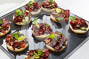 Appetizing canapes with meat sandwiches. Catering for business meetings, events and celebrations. Close-up
