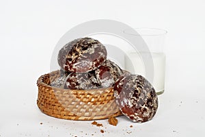 Appetizing chocolate cakes in a wicker basket and a glass of milk
