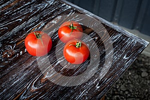 Appetizing composition in the kitchen of ripe red large tomatoes