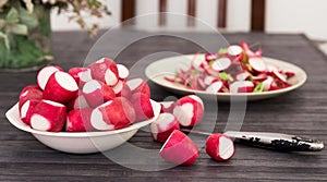 Cooked crispy radish in white bowl on wooden table photo