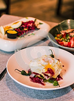 Appetizing cooked egg on a top of chopped ham and roasted peppers