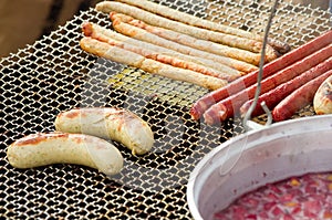 Appetizing delicious fried meat frankfurters sausage on a barbecue grill outdoors.