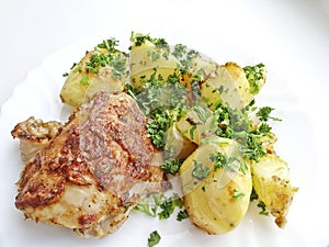 Appetizing dish - baked chicken and potatoes on a platter.