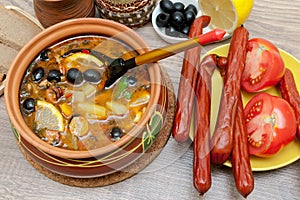 Appetizing dish of russian hodgepodge soup in ceramic pot photo