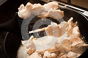 Appetizing fatty chicken meat for a dietary diet. Dynamic photo of mixing chicken breast in a pan