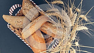 appetizing fresh buns of bread in a wicker basket and ears of wheat