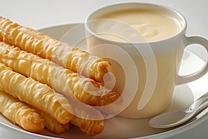 Appetizing Fresh Cheese Sticks with Creamy Cup of Cafe au Lait on a Clean White Background Breakfast, Snack, or Coffee Break photo