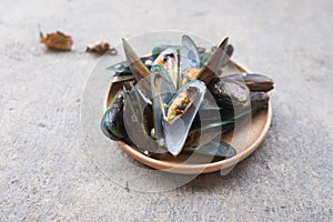 Appetizing fresh steamed mussels on wooden dish