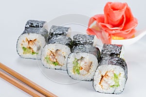 Appetizing fresh sushi rolls with rice, shrimps, avocado and cucumber on light background