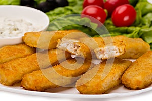 Appetizing fried fish fingers with vegetables