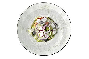 Appetizing greek salad in a plate. View from above. Isolated over white background