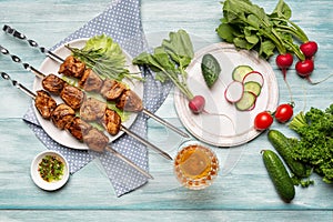 Appetizing homemade shish kebab, sliced and whole vegetables, a glass of wine.