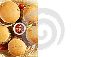 Appetizing juicy burgers with sauce on a wooden board. Unhealthy and tasty junk food. Isolated on white background. Space for text