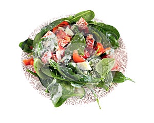 Appetizing light low calorie vegetarian salad from raw fresh vegetables with greens and yogurt on round plate studio shot isolated