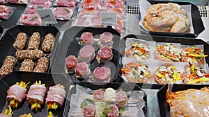 Appetizing meat products are on display in special containers. Meat products for sale in a supermarket window.