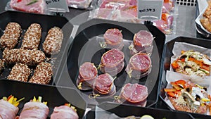 Appetizing meat products are on display in special containers. Meat products for sale in a supermarket window.