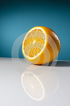Appetizing orange, with reflection on a blue background