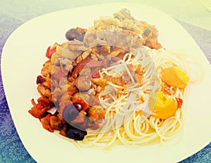 Appetizing pasta with vegetables grilled meat and baked egg yolk