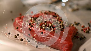 Appetizing piece of raw meat sprinkled with aromatic spices. Very beautiful studio shot. Camera Phantom Flex.