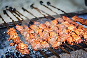 Appetizing pieces of pork meat are strung on skewers and have been frying on a grill