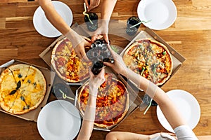 Appetizing pizza on the table and hands above it