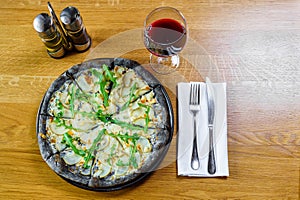 Appetizing pizza on a wooden table with cheese and rucola