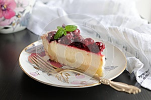 Appetizing portioned piece of cottage cheese tart and cherries on a porcelain plate. Tea party, morning, five o