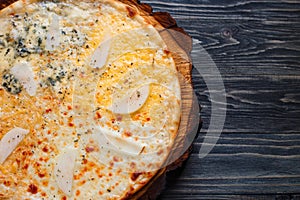 Appetizing quattro formaggi cheese pizza with pear served on woo