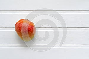 Appetizing ripe juicy Brazilian mango fruit from the tropics on a white wooden background with place for text. Exotic