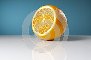 Appetizing ripe orange with reflection on a blue background