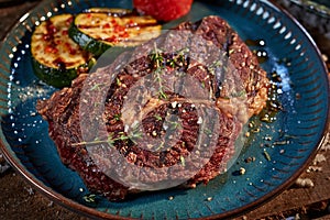 Appetizing steak with seasonings and vegetables on plate
