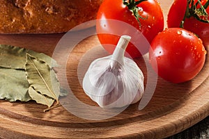 Appetizing still life of vegetables bread and seasoning on a wooden board