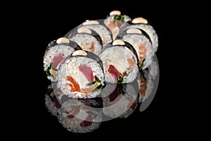 appetizing sushi roll futomaki on a black background with reflection. Sushi menu. Japanese kitchen, restaurant.