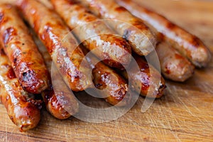 Appetizing toasted sausages with turkey lie on a wooden board