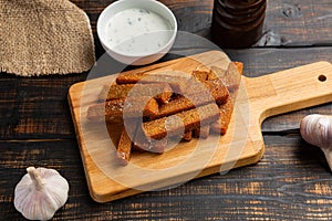 appetizing toasted toasts from rye bread on dark wooden background