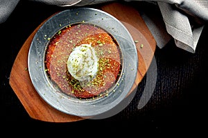 Appetizing Turkish sweetness Kanafeh made with shredded filo pastry with honey, pistachios and white ice cream