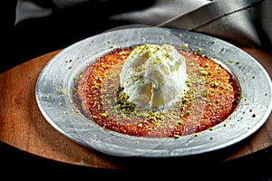 Appetizing Turkish sweetness Kanafeh made with shredded filo pastry with honey, pistachios and white ice cream