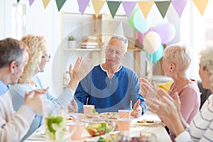 Applauding birthday man at dinner party