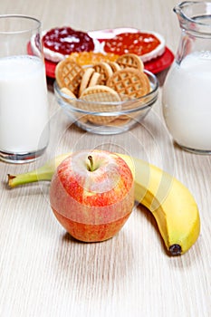 Apple, banana anc cookies on table