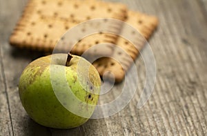 Apple and biscuits on a wooden table	