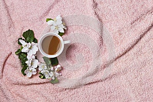 Apple blooming with cup of coffee on fur towel flat lay copy space