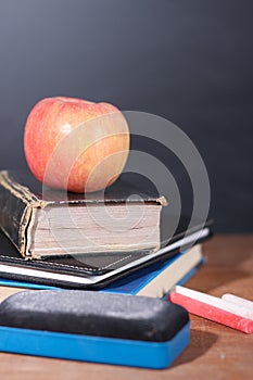 Apple, Books and Chalks with Blackboard Background