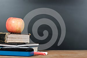 Apple, Books and Chalks with Blackboard Background